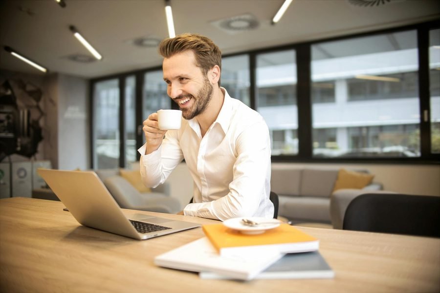 Profissional tomando café e trabalhando com notebook